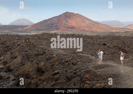 Lanzarote-Landschaft - Menschen zu Fuß in die karge Vulkanlandschaft auf Europa Los Hervideros, Lanzarote, Kanarische Inseln Stockfoto