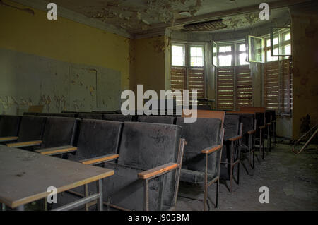 Leere Stühle vergessen von alten Publikum im zerstörten Haus. Stockfoto