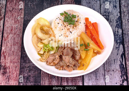 Thai Jasminreis im amerikanischen koreanischen Stil, Reis mit geschnittenem Schweinefleisch Steak, in Scheiben geschnittenen Karotten, Kartoffeln, Zwiebeln und gebratener Kohl gekrönt Sesames und Schalotten. Stockfoto