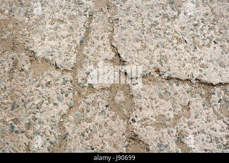 Stein-Hintergrund. Close-up Teil des Belags Beton mit kleinen Kieselsteinen und Sand, hämmerte in Risse. Stockfoto