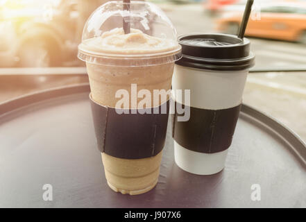 paar Frappe und Kaffee Tassen auf schwarzen runden Tisch Stockfoto