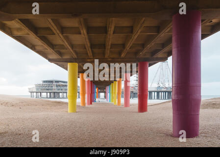 Schuß unter Pier mit Farbe lackiert Spalten am Strand bei Sonnenuntergang. Stockfoto