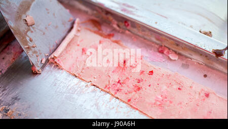 Der Prozess der Herstellung Gebratenes Eis Brötchen beim Einfrieren Pfanne. Gerollte Eis, handgemachte Dessert aus Milch, Schokolade und frischen Erdbeeren. Stockfoto