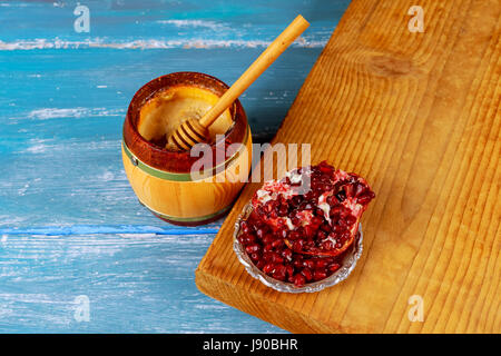 Granatäpfel und Glas Honig auf Sackleinen. Alten rustikalen hölzernen Hintergrund Stockfoto