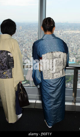 Japanische Frauen gekleidet in traditionelle Yukata genießen Sie die Aussicht von der Spitze des Tokyo skytree. Stockfoto