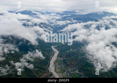 Bergen von Nepal. Schöne Helikopterblick eines Flusstales zwischen bewölkt Bergen. Stockfoto