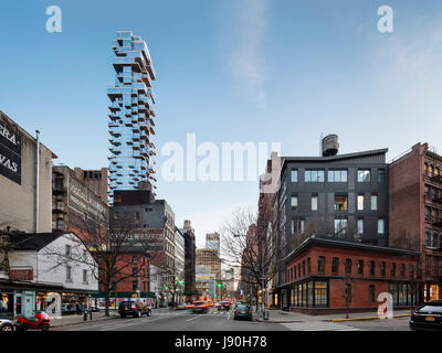 Kontextbezogene Außenansicht, Blick nach Süden am West Broadway in der Abenddämmerung. 56 Leonard Street, New York, Vereinigte Staaten. Architekt: Herzog + de Meuron, 2017. Stockfoto