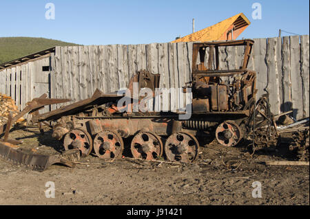 Alter rostiger gebrochener Traktor steht im Dorf Stockfoto