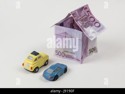 Haus mit 500 Euro-Banknoten und Autos parkten außerhalb isoliert auf weißem Hintergrund Stockfoto