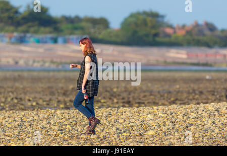 Junge Frau zu Fuß am Strand am späten Abend licht. Stockfoto