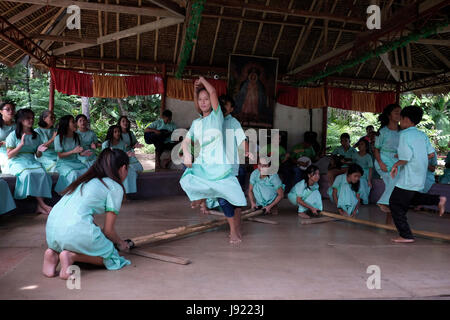 Filipino junge Schulmädchen, die Durchführung der Tinikling befindet sich ein traditioneller philippinischer Volkstanz entstanden während der spanischen Kolonialzeit in der Insel Bohol in den Central Visayas Region auf den Philippinen Stockfoto