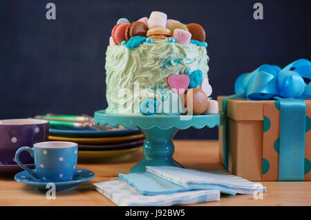 Happy Fathers Day oder männliche Partei Geburtstagstisch mit Showstopper Kuchen mit Süßigkeiten, Marshmallows und Macarons Cookies dekoriert. Stockfoto