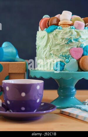 Happy Fathers Day oder männliche Partei Geburtstagstisch mit Showstopper Kuchen verziert mit Süßigkeiten, Marshmallows und Macarons Cookies, vertikale. Stockfoto