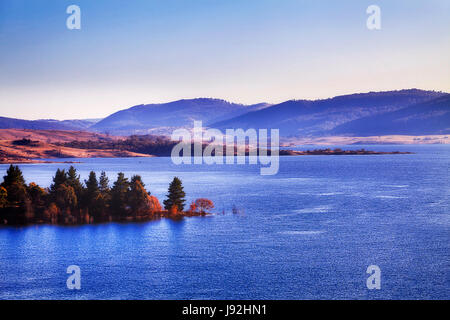 Jindabyne See an einem sonnigen Wintertag über Baumwipfel auf das blaue Wasser und die entfernten Hügel Bereich von oben gesehen. Stockfoto