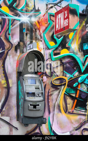 Unabhängige ATM Gerät an einer Graffitiwand bedeckt in New York City Stockfoto