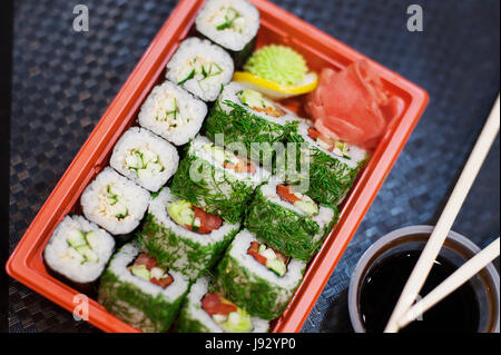 Draufsicht der Bento-to Go-Kunststoff-Box, gemischte Nigiri und verschiedene Sushi Rollen in Lunchpaket auf hölzernen Hintergrund platzieren. Stockfoto