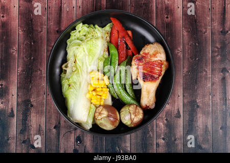 Chicken Sie hausgemacht, Drumstick Steak und gegrilltes Gemüse auf koreanische Modellplatten wie Chinakohl, Erbsen, Karotten, Mais und Auberginen. Stockfoto