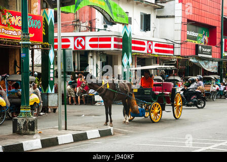 YOGYAKARTA, Indonesien - SEPTEMBER, 13: Main Street in Yogjakrata voll von Nahverkehr - Pferde, Rikschas, Wagen, Motorräder und Autos in Yogyakar Stockfoto