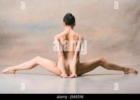 Die Ballerina ist mit den hinteren Beinen weit auseinander sitzen. Stockfoto