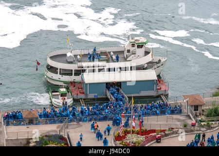 Touristen in blauen Regenmäntel einsteigen in das Mädchen des Nebels in Niagara Falls, Kanada. Stockfoto