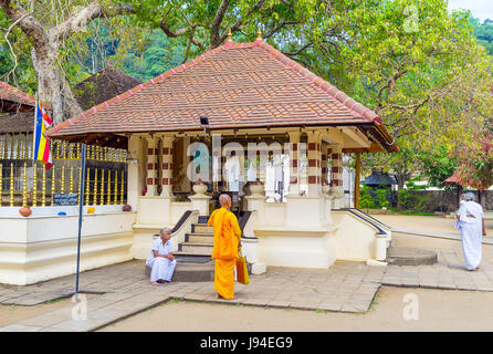 KANDY, SRI LANKA - NOVEWMBER 28, 2016: der Mönch neben dem kleinen Tempel auf dem Gebiet von Natha Devale Komplex, am 28. November in Kandy. Stockfoto