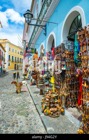 SALVADOR, Brasilien - 9. März 2017: Souvenirläden verkaufende Taschen und lokales Kunsthandwerk Linie der traditionellen kopfsteingepflasterten Straßen des historischen Pelourinho. Stockfoto