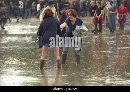 Glastonbury Festival 1998, tritt eines der schlechtesten Jahre für Schlamm, wo Festival Teilnehmer Schlamm-Baden ging zwischen beobachten live-Musik. Das jährliche Festival zieht bis zu 175.000 Menschen würdig Farm, wo sie live-Musik sehen, Auftritten auf zahlreichen Bühnen einschließlich der Pyramide-Bühne. Stockfoto