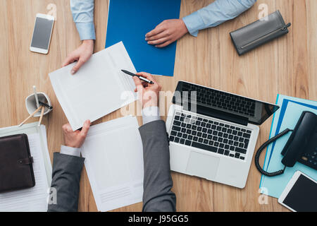 Geschäftsleute mit einem Treffen im Büro, der Mann zeigt der Frau einen Vertrag und zu erklären, Ansicht von oben Stockfoto