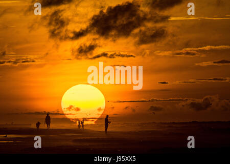 South Carolina, USA. 5. Juni 2017. Menschen am Strand, die Silhouette von der aufgehenden Sonne an einem bewölkten Morgen 5. Juni 2017 in Folly Beach, South Carolina. Folly Beach ist eine schrullige Strandgemeinde außerhalb Charleston Einheimischen als Edge of America bekannt. Bildnachweis: Planetpix/Alamy Live-Nachrichten Stockfoto