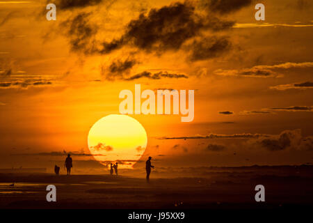 South Carolina, USA. 5. Juni 2017. Menschen am Strand, die Silhouette von der aufgehenden Sonne an einem bewölkten Morgen 5. Juni 2017 in Folly Beach, South Carolina. Folly Beach ist eine schrullige Strandgemeinde außerhalb Charleston Einheimischen als Edge of America bekannt. Bildnachweis: Planetpix/Alamy Live-Nachrichten Stockfoto