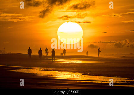 South Carolina, USA. 5. Juni 2017. Menschen am Strand, die Silhouette von der aufgehenden Sonne an einem bewölkten Morgen 5. Juni 2017 in Folly Beach, South Carolina. Folly Beach ist eine schrullige Strandgemeinde außerhalb Charleston Einheimischen als Edge of America bekannt. Bildnachweis: Planetpix/Alamy Live-Nachrichten Stockfoto
