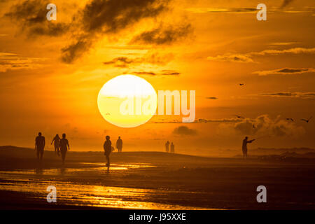 South Carolina, USA. 5. Juni 2017. Menschen am Strand, die Silhouette von der aufgehenden Sonne an einem bewölkten Morgen 5. Juni 2017 in Folly Beach, South Carolina. Folly Beach ist eine schrullige Strandgemeinde außerhalb Charleston Einheimischen als Edge of America bekannt. Bildnachweis: Planetpix/Alamy Live-Nachrichten Stockfoto