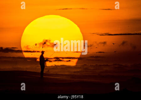 South Carolina, USA. 5. Juni 2017. Ein Fischer wirft seine Linie am Strand bei Sonnenaufgang an einem bewölkten Morgen 5. Juni 2017 in Folly Beach, South Carolina. Folly Beach ist eine schrullige Strandgemeinde außerhalb Charleston Einheimischen als Edge of America bekannt. Bildnachweis: Planetpix/Alamy Live-Nachrichten Stockfoto