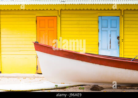 Farbigen Holz-Haus am Strand gelb Orange mit kleinen Boot Stockfoto