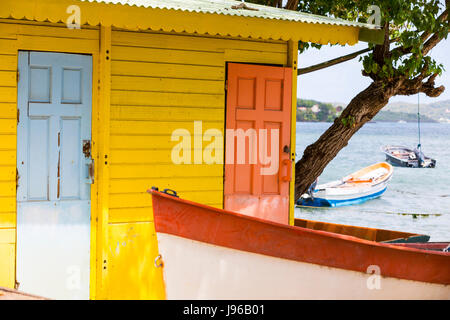 Farbigen Holz-Haus am Strand gelb Orange mit kleinen Boot Stockfoto