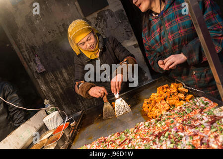 Frau Verkäufer Zubereitung Tofu, Street-Lebensmittelmarkt, muslimische Viertel, Xi ' an, Provinz Shaanxi, China Stockfoto