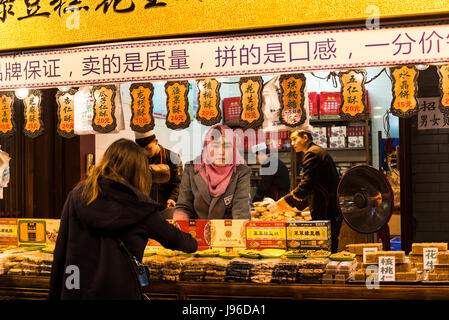 Frauen, Verkauf von Süßigkeiten, Street Food Markt, muslimische Viertel, Xi ' an, Provinz Shaanxi, China Stockfoto