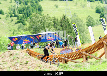 Mann springt mit seinem MTB während einer Freeride World Tour-Meisterschaft in Frankreich (hier im Dorf von "Deux Alpes") Stockfoto