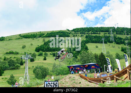 Mann springt mit seinem MTB während einer Freeride World Tour-Meisterschaft in Frankreich (hier im Dorf von "Deux Alpes") Stockfoto