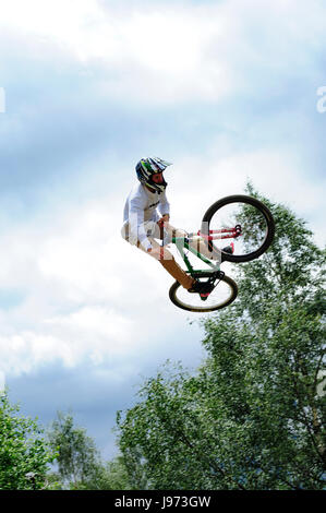 Mann springt mit seinem MTB während einer Freeride World Tour-Meisterschaft in Frankreich (hier im Dorf von "Deux Alpes") Stockfoto