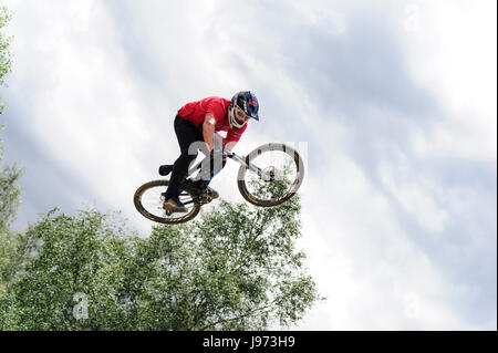 Mann springt mit seinem MTB während einer Freeride World Tour-Meisterschaft in Frankreich (hier im Dorf von "Deux Alpes") Stockfoto