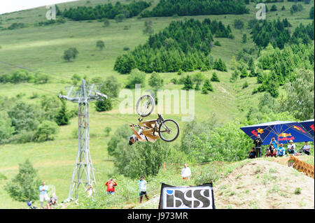 Mann springt mit seinem MTB während einer Freeride World Tour-Meisterschaft in Frankreich (hier im Dorf von "Deux Alpes") Stockfoto