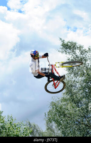 Mann springt mit seinem MTB während einer Freeride World Tour-Meisterschaft in Frankreich (hier im Dorf von "Deux Alpes") Stockfoto