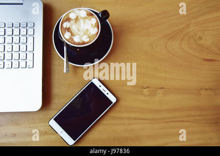 Büro-Zeug mit Smartphone-Laptop und Kaffee Tasse Maus Editor Ansicht von oben geschossen. Stockfoto