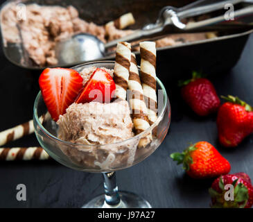 Schokoladen-Sorbet mit Erdbeeren und Waffel Spiralen Dessert in einer Glasschale Stockfoto
