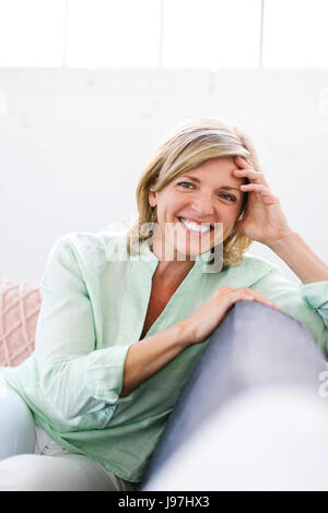 Porträt der Frau sitzt auf dem sofa Stockfoto