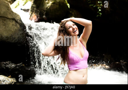 Porträt der Frau stand vor Wasserfall Stockfoto