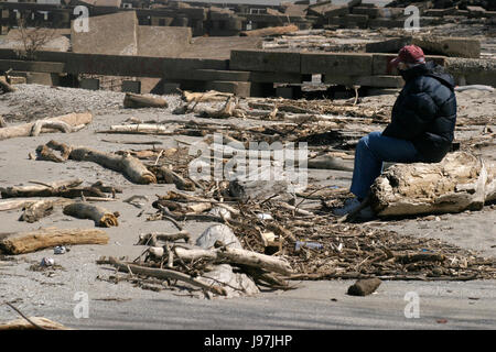 Mann allein am Ufer des Lake Erie, Ohio, zwischen toten Ästen Wasser festgelegten Stockfoto