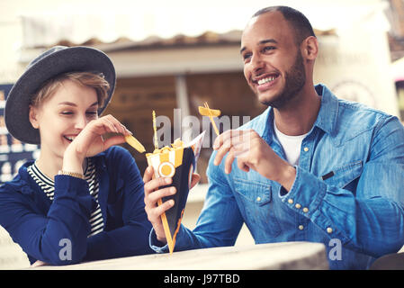 Junge Erwachsene paar Teilen Pommes frites Stockfoto