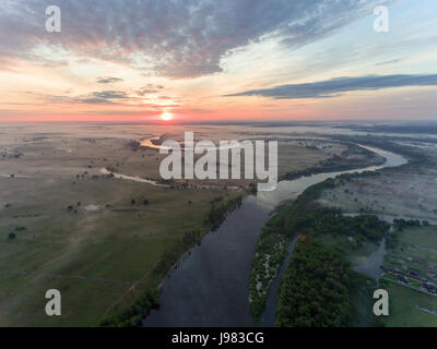 Luftaufnahme des Flusses bei Sonnenaufgang, fliegen über Morgennebel am Fluss Stockfoto